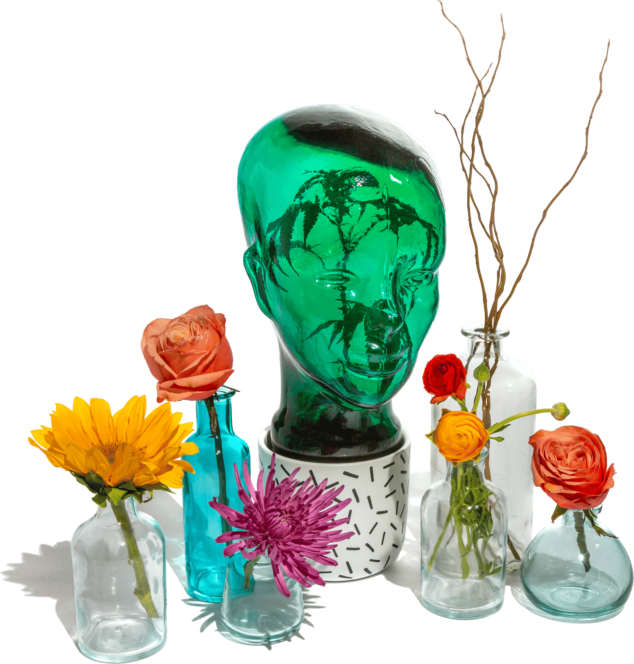 Green glass head and flowers in vases